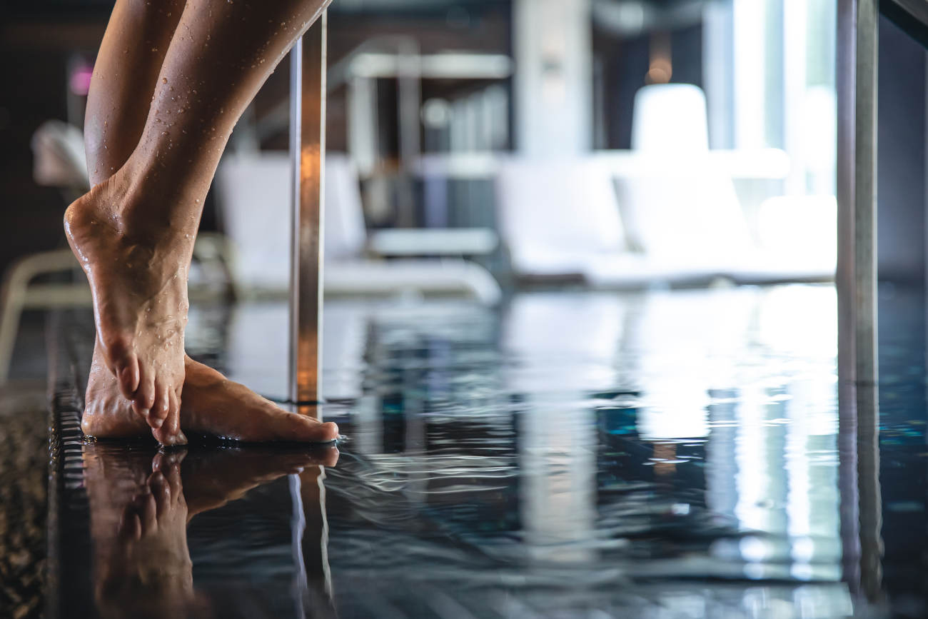 Close-up, a woman's foot steps into the pool, the concept of relaxation in the spa complex.